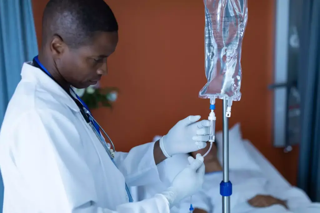 A detailed medical illustration showcasing the chemo infusion process. In the foreground, a patient's arm with an IV line connected to a clear fluid-filled bag, the infusion slowly dripping into the vein. The middle ground features a nurse carefully monitoring the infusion, their expression serene and focused. In the background, a clinical hospital setting with medical equipment and a soothing, muted color palette. Bright, diffused lighting casts a gentle glow, conveying a sense of care and professionalism. The scene captures the precise, delicate nature of administering chemotherapy, highlighting the expertise and attentiveness required. A detailed medical illustration showcasing the chemo infusion process. In the foreground, a patient's arm with an IV line connected to a clear fluid-filled bag, the infusion slowly dripping into the vein. The middle ground features a nurse carefully monitoring the infusion, their expression serene and focused. In the background, a clinical hospital setting with medical equipment and a soothing, muted color palette. Bright, diffused lighting casts a gentle glow, conveying a sense of care and professionalism. The scene captures the precise, delicate nature of administering chemotherapy, highlighting the expertise and attentiveness required.