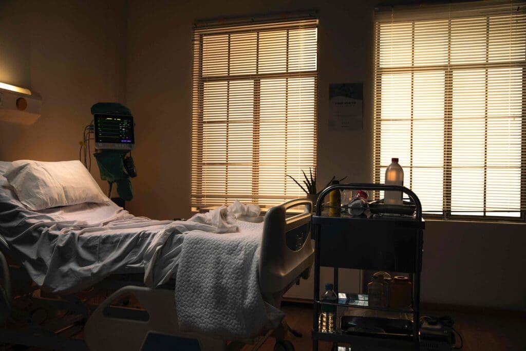A neatly organized hospital room, bathed in warm, natural lighting that filters through large windows A neatly organized hospital room, bathed in warm, natural lighting that filters through large windows