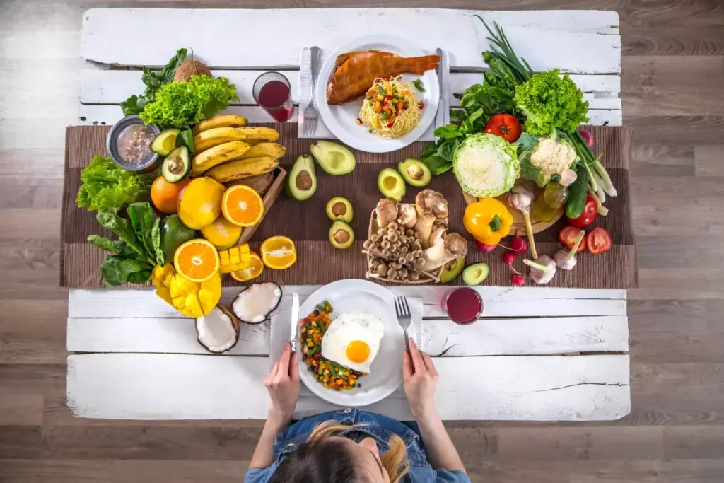 A nourishing table setting featuring a balanced spread of whole foods suitable for a post-prostatectomy diet. In the foreground, a plate showcases a variety of nutrient-dense ingredients like leafy greens, vibrant vegetables, lean protein, and whole grains. In the middle ground, a glass of water and fresh fruit accent the scene. The background depicts a warm, inviting kitchen environment with natural lighting filtering through a window, casting a soft, comforting glow. The overall atmosphere conveys a sense of wellness, healing, and the importance of mindful nutrition during prostate cancer recovery.