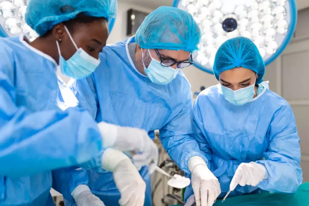 A surgical theater at a modern hospital, filled with soft, warm lighting. In the center, a detailed surgical scene of a non-small cell lung cancer (NSCLC) resection procedure. The patient lies on the operating table, surrounded by a team of skilled surgeons and nurses in sterile attire. Their hands move with precision, removing the affected lung lobe through a thoracic incision. The scene conveys a sense of professionalism, expertise, and the gravity of the life-saving operation. The background is blurred, emphasizing the focus on the intricate surgical work. Detailed textures of tissue, instruments, and surgical gowns create a sense of realism. An atmosphere of concentration and dedication pervades the scene.