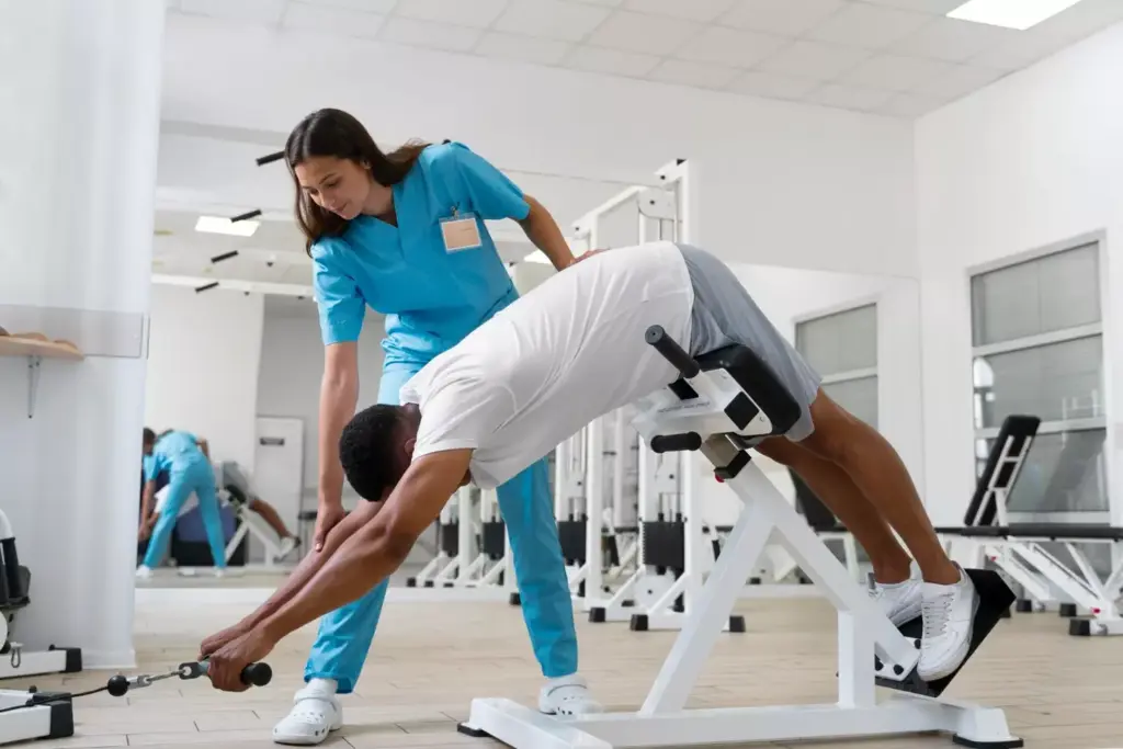 A well-lit, clean and organized physical therapy clinic. In the foreground, a massage table and various rehabilitation equipment like exercise balls, resistance bands, and foam rollers. In the middle ground, a patient performing knee exercises under the supervision of a physical therapist. The background features wall-mounted posters and diagrams depicting the anatomy and recovery process of an ACL injury. Warm, natural lighting illuminates the scene, conveying a sense of care, professionalism and a dedicated recovery environment. A well-lit, clean and organized physical therapy clinic. In the foreground, a massage table and various rehabilitation equipment like exercise balls, resistance bands, and foam rollers. In the middle ground, a patient performing knee exercises under the supervision of a physical therapist. The background features wall-mounted posters and diagrams depicting the anatomy and recovery process of an ACL injury. Warm, natural lighting illuminates the scene, conveying a sense of care, professionalism and a dedicated recovery environment.