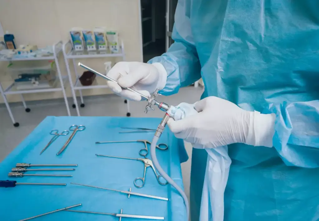 A well-lit, high-resolution image of a professional medical setup for laparoscopic surgery. In the foreground, a set of stainless steel laparoscopic instruments including graspers, scissors, and an energy device. In the middle ground, a modern laparoscopic camera and a light source. In the background, a large, high-definition display showing a detailed view of the surgical site. The scene conveys a sense of precision, technology, and the specialized nature of minimally invasive surgery. A well-lit, high-resolution image of a professional medical setup for laparoscopic surgery. In the foreground, a set of stainless steel laparoscopic instruments including graspers, scissors, and an energy device. In the middle ground, a modern laparoscopic camera and a light source. In the background, a large, high-definition display showing a detailed view of the surgical site. The scene conveys a sense of precision, technology, and the specialized nature of minimally invasive surgery.