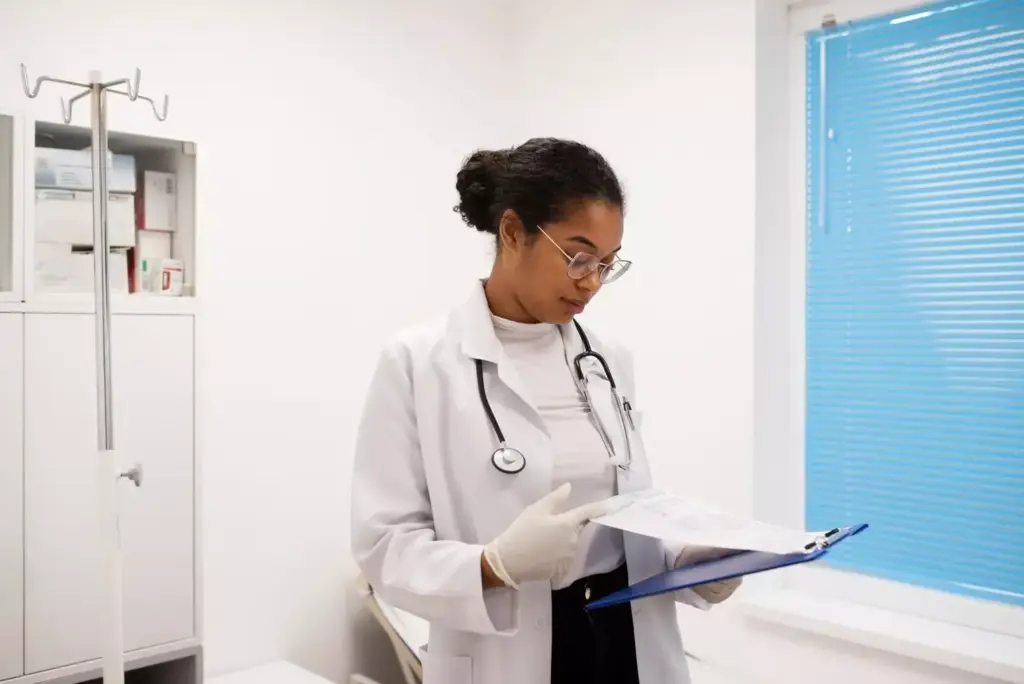 a portrait of an oncologist in a white lab coat, standing in a modern medical clinic with sleek minimalist decor and large windows letting in warm natural light. the oncologist is holding a clipboard and has a thoughtful, focused expression as they review patient information. the background is blurred, placing the oncologist in sharp focus. the image conveys a sense of professionalism, expertise, and a dedication to patient care. a portrait of an oncologist in a white lab coat, standing in a modern medical clinic with sleek minimalist decor and large windows letting in warm natural light. the oncologist is holding a clipboard and has a thoughtful, focused expression as they review patient information. the background is blurred, placing the oncologist in sharp focus. the image conveys a sense of professionalism, expertise, and a dedication to patient care.